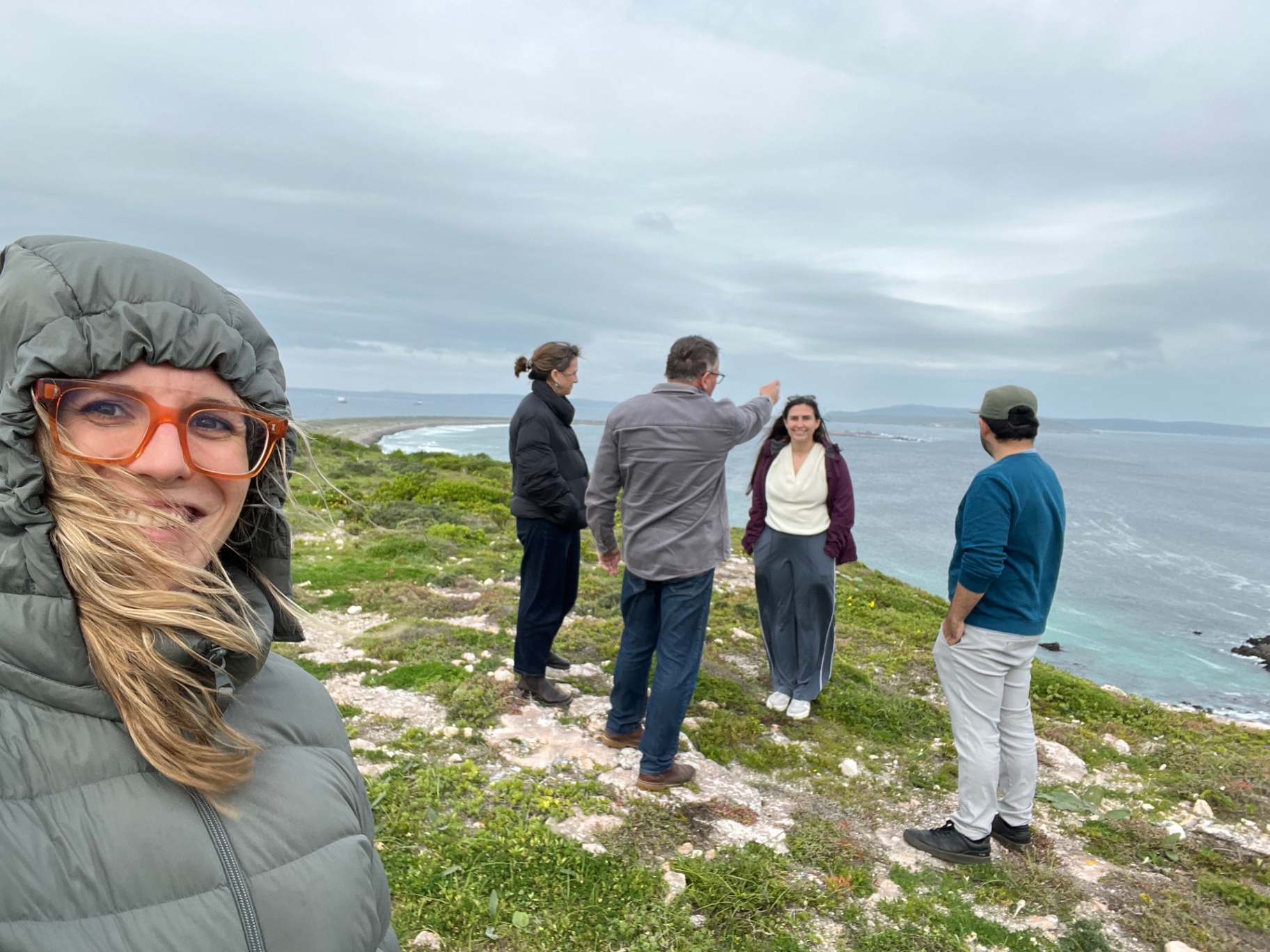 A group surveying the coast together above the ocean
