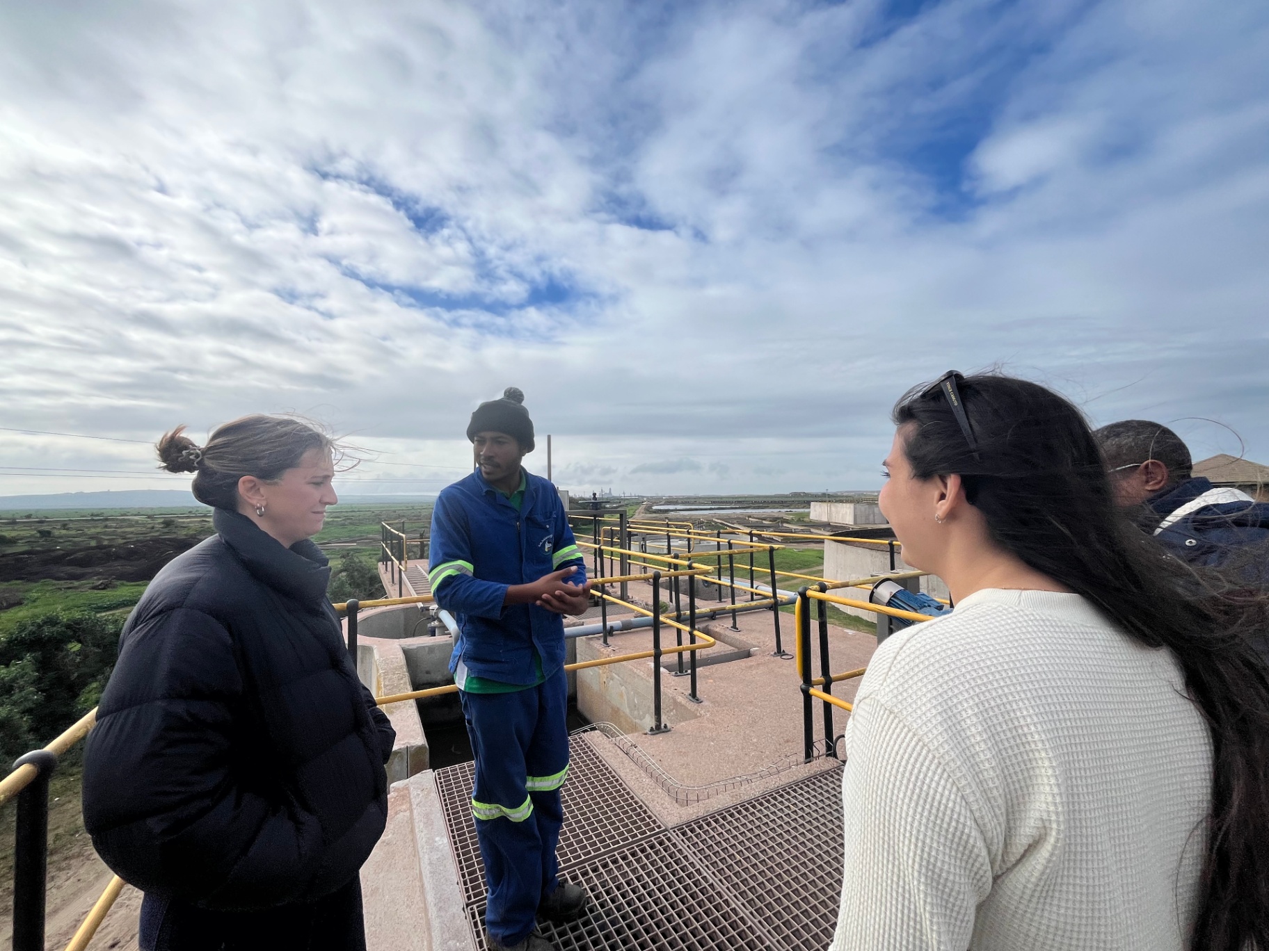 A group discussing work at a coastal industrial site